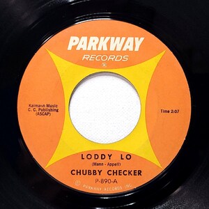 May include: A black and orange vinyl record with the title "LODDY LO" by "CHUBBY CHECKER" and the record label "PARKWAY RECORDS".