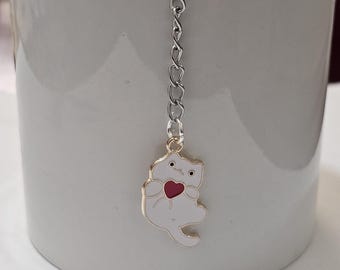 Infusor de té en forma de bola de malla con dije de gato blanco y corazón rojo