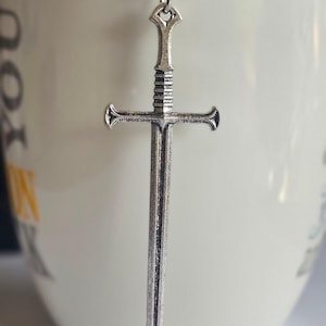 Tea infuser with medieval sword charm
