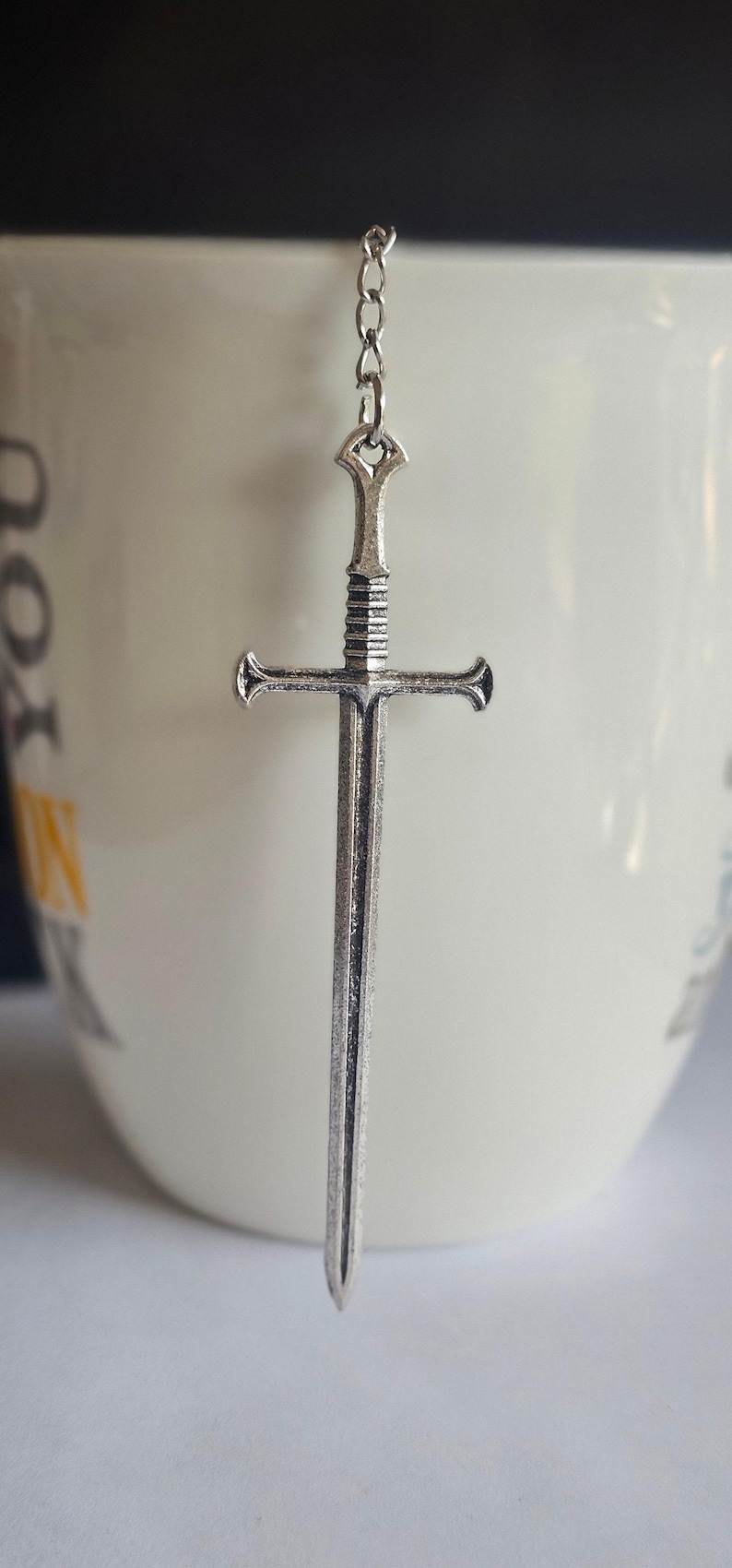 Tea infuser with medieval sword charm