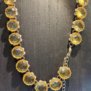 Gargantilla con gemas de cristal color citrino, brillante y reluciente. Cada gema está rodeada de diamantes de imitación.