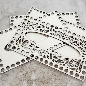 Könnte beinhalten: Vier unfertige Holz-Stricknadelbretter mit einem floralen Design. Die Bretter sind übereinander gestapelt.