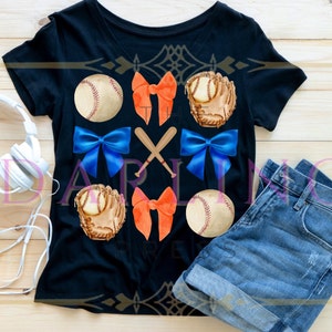 May include: A black t-shirt with a baseball themed design. The design features baseballs, gloves, bats, and bows in orange, blue, and white.
