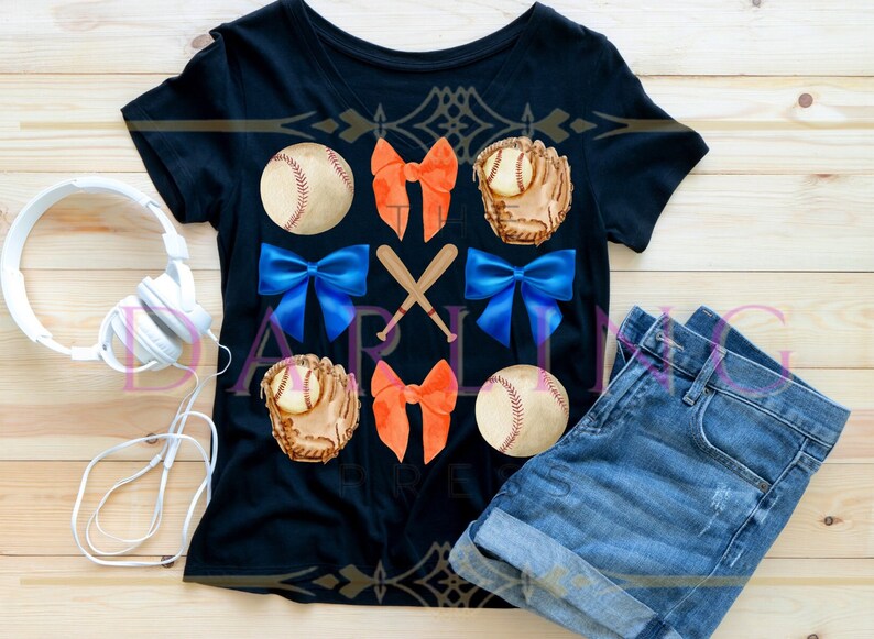 May include: A black t-shirt with a baseball themed design. The design features baseballs, gloves, bats, and bows in orange, blue, and white.