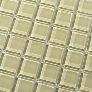 May include: A sheet of small, square, beige glass tiles with a beveled edge. The tiles are arranged in a staggered pattern.