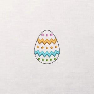 Pode incluir: Design de ovo de Páscoa bordado sobre fundo branco. O ovo tem um contorno preto e é decorado com padrões de ziguezague e pontos em tons de dourado, turquesa, rosa e verde. Um design festivo e colorido.