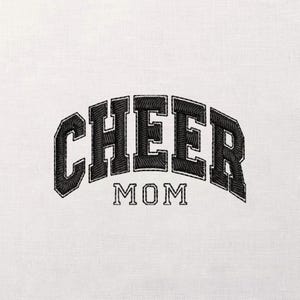 May include: A white ceramic mug with a black handle and the text "But First, Coffee" in a black, handwritten-style font. The mug is on a white surface.