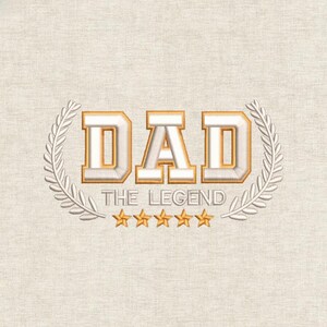 Op de afbeelding: Geborduurd ontwerp met het woord "DAD" in een vetgedrukte, goudkleurige letter, omringd door een lauwerkrans. Daaronder de tekst "THE LEGEND" en vijf gouden sterren op een beige achtergrond.