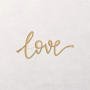 May include: Embroidered gold-coloured word "love" on a white background. The word is styled to look like it's made of rope, with detailed rope ends. The background has a subtle, textured appearance.