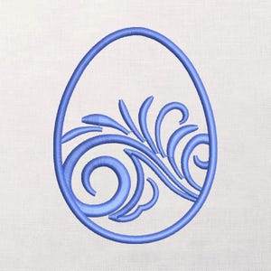 May include: A blue embroidered design of an egg shape with a swirling floral pattern inside. The egg shape is outlined in blue, and the floral design is also blue. The background is a light, textured fabric.