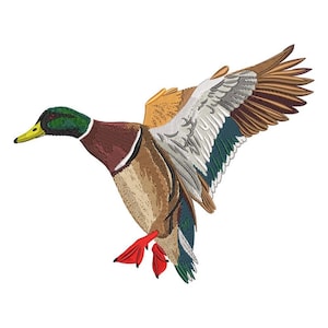 Może przedstawiać: Wyszywany obraz kaczki krzyżówki w locie, z szczegółowymi szwami. Kaczka ma zieloną głowę, brązowy korpus i skrzydła w odcieniach brązu, bieli i błękitu. Jej czerwone stopy są wyciągnięte, a żółty dziób otwarty.