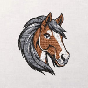 Pode incluir: Cabeça de cavalo bordada em perfil, com fios castanhos, brancos e cinzentos. O cavalo tem uma crina detalhada e uma expressão focada. A obra de arte é colocada sobre um fundo branco liso, destacando o bordado intrincado.