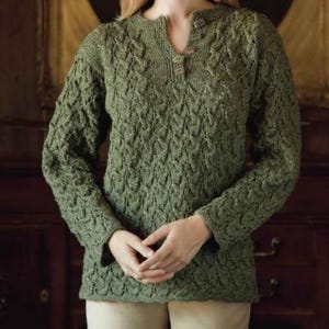 May include: A green knitted sweater with a textured pattern. The long-sleeved top features a V-neckline with a button closure. The sweater's design includes a detailed, raised pattern across the body and sleeves, creating a visually interesting texture.