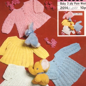 May include: Four knitted baby sweaters in pink, yellow, blue, and green. The sweaters are laid out on a red surface with stuffed animals. The sweaters are made with 3 ply pure wool and are 18 inches in size.