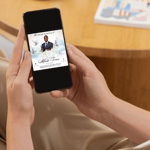 Pu&ograve; includere: Uno smartphone che mostra un biglietto di memoria digitale con una foto di un uomo in abito e cravatta. Il biglietto ha uno sfondo bianco con colombe e nuvole. Il testo sul biglietto recita "In memoria affettuosa di" e "Alphonso Jones".