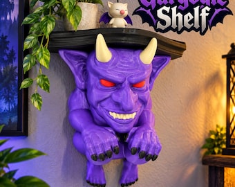 May include: A wall-mounted shelf featuring a purple gargoyle figure with cream-colored horns, glowing red eyes, and sharp teeth. The shelf surface is black. Text in the upper right corner reads Gargoyle Shelf. A small white creature figure sits on top.