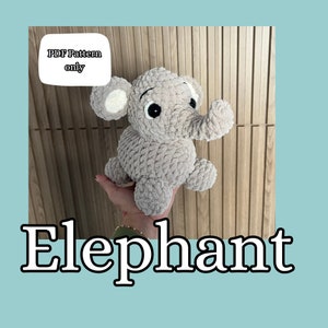May include: A gray crocheted elephant plush toy with black eyes and a white patch on its ear. The toy is being held by a hand. The text "PDF Pattern only" is visible in the image.