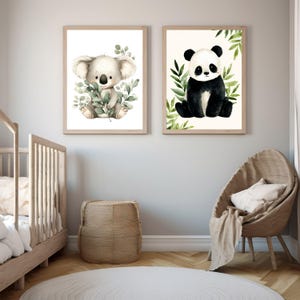 Könnte beinhalten: Zwei gerahmte Aquarelldrucke mit entzückenden Tieren. Ein Druck zeigt einen Koala, der Blätterzweige hält, der andere einen Panda, der von grünem Laub umgeben ist. Beide Drucke haben einen hellbeigen Hintergrund und sind in hellbraunen Rahmen gefasst.