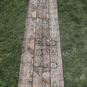 May include: A vintage patchwork runner rug with a brown, beige, and pink color scheme. The rug is made of woven fabric and has a distressed look.