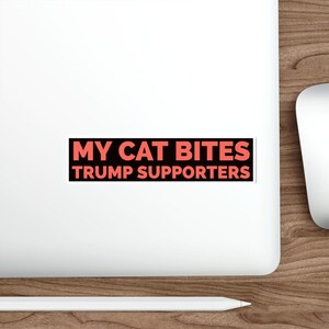 May include: Black and red sticker with the text "My Cat Bites Trump Supporters".