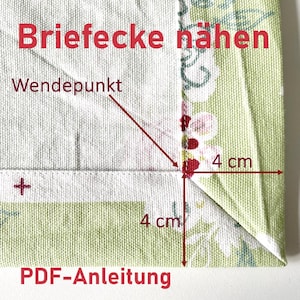 Könnte beinhalten: Nahaufnahme einer Stoffecke mit dem Text "Briefecke nähen" und "PDF-Anleitung" in Rot. Die Ecke wird auf jeder Seite mit 4 cm gemessen. Der Stoff hat ein Blumenmuster mit grünen und weißen Farben.