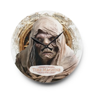 Op de afbeelding: Een ronde wandklok met een witte achtergrond waarop een griezelige, bleke, gekapte figuur met grote, gele ogen te zien is. De wijzerplaat van de klok is bedekt door de figuur, maar de wijzers zijn zichtbaar. De klok heeft een rood en wit opschrift met de tekst "The Time Machine H.G. Wells".
