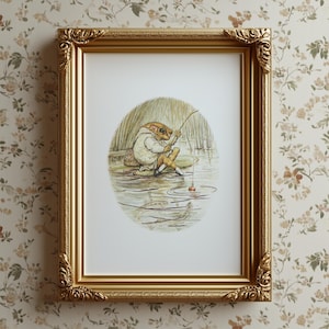 Könnte beinhalten: Ein gerahmter Druck mit einer skurrilen Illustration eines angelnden Frosches. Das Kunstwerk, das sich in einem goldenen, verzierten Rahmen befindet, zeigt den Frosch in einem weißen Mantel und gelben Hosen, der auf einem Seerosenblatt sitzt, mit einer Angelrute und einer roten Pose. Der Hintergrund zeigt Wasser und Schilf.