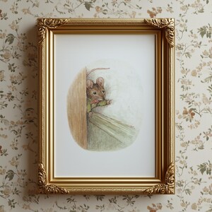 May include: A framed print featuring a watercolor illustration of a mouse peeking out from behind a door. The mouse is wearing a green jacket and a pink bow tie. The frame is gold with ornate detailing.