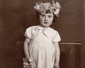 Mädchen in einem weißen Kleid mit einer Blume in der Hand und einem schönen geblümten Hut auf dem Kopf, Original Sepia Foto von 1938