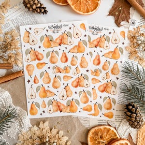 May include: Two sheets of pear-themed stickers with the text "BujoJej #840". The stickers feature watercolor illustrations of pears in various sizes, with green leaves and small stars. Dried orange slices and cinnamon sticks are also visible.