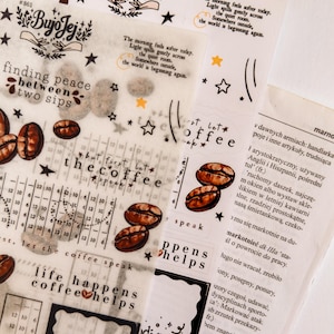 May include: Assorted decorative stickers with coffee bean illustrations, text, and star accents. The stickers feature phrases like "finding peace between two sips" and "life happens coffee helps".