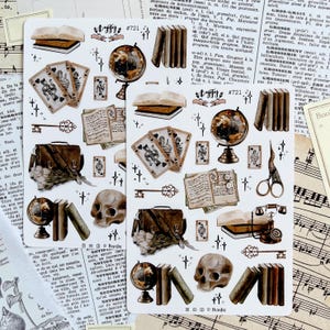 Può includere: Un foglio di adesivi con illustrazioni vintage di libri, chiavi, globi, carte da gioco, teschi e altri oggetti. Gli adesivi sono stampati su carta bianca con uno sfondo marrone chiaro.