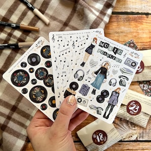 May include: Three sheets of stickers featuring music-themed illustrations. The first sheet has black and white musical notes, the second sheet has a variety of music-related icons, and the third sheet has black vinyl records with floral designs.
