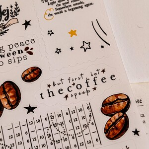May include: A sheet of decorative stickers with coffee-themed designs. Includes coffee beans, stars, and phrases like "but first, let the coffee speak." The stickers have a handwritten aesthetic with a neutral color palette.