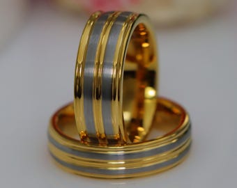 May include: Two gold and silver wedding bands with a brushed finish. The bands have two gold stripes around the center.