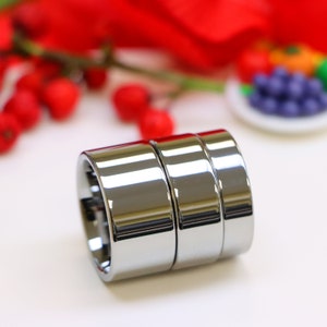 May include: Three silver rings stacked on top of each other. The rings are smooth and shiny, and they have a polished finish.