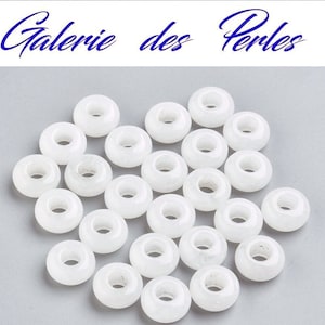 May include: A collection of white round beads with a hole in the center. The beads are made of a smooth, opaque material and are perfect for jewelry making or crafting.