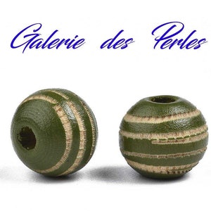 Puede incluir: Dos cuentas de madera redondas de color verde con rayas blancas. Las cuentas tienen un agujero en el centro.