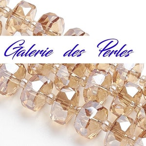 Peut inclure: Un brin de perles en verre facettées de couleur brun clair. Les perles sont enfilées sur un fil transparent et ont une finition légèrement irisée. Les perles sont disposées de manière aléatoire et sont toutes de taille approximativement identique.