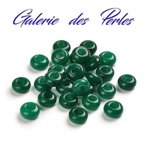 Peut inclure: Un tas de 20 perles de jade vert en forme de beigne. Les perles sont lisses et polies, avec un trou au centre de chaque perle.