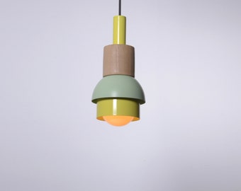 Può includere: Una lampada a sospensione gialla, verde e legno con una lampadina rotonda bianca.