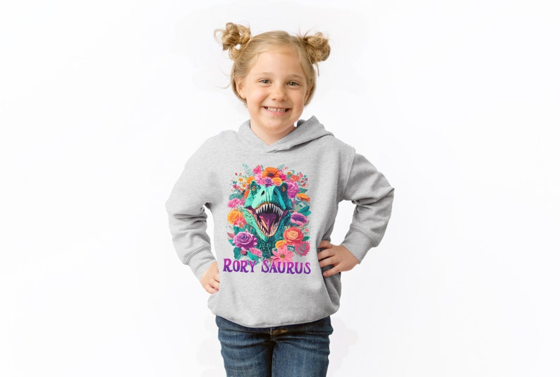 May include: A gray hooded sweatshirt with a colorful floral design featuring a dinosaur head with the text "Rory Saurus" printed on the front.
