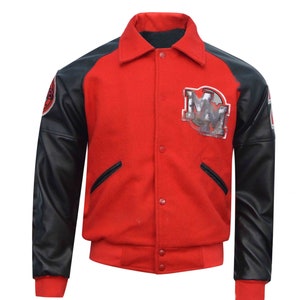Può includere: Una giacca da baseball rossa e nera con un grande logo "MM" sul davanti. La giacca ha una manica in pelle nera e un corpo in lana rossa.