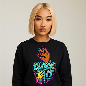 May include: Black sweatshirt with a colorful graphic that says "CLOCK IT". The graphic includes a hand gesture, a clock, and dripping paint effect. The design is in shades of orange, blue, yellow, and pink.