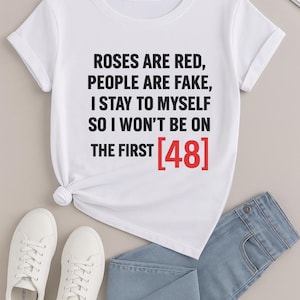 Puede incluir: Camiseta blanca con el texto "ROSES ARE RED, PEOPLE ARE FAKE, I STAY TO MYSELF SO I WON'T BE ON THE FIRST [48]" en negro y rojo. La camiseta se combina con vaqueros azules y zapatillas blancas.