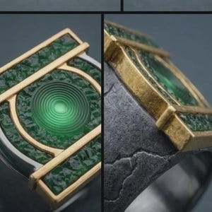 May include: A ring featuring a central green circular emblem with concentric rings, framed by a gold-toned rectangular border. The surrounding surface has a textured green finish, while the band is made of a dark, weathered gray metal.