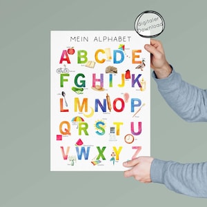 May include: A colorful educational poster featuring the German alphabet, "Mein Alphabet," with each letter illustrated with a corresponding image. The poster is held by a person. The top right corner has a digital download label.