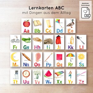 May include: A collection of 26 flashcards, each displaying a letter of the alphabet with a corresponding watercolor illustration. Images include an apple, book, kite, duck, bicycle, and watermelon. The text "Lernkarten ABC" is at the top of the cards.