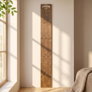 May include: A tall, vertical wooden growth chart made of five interlocking puzzle-piece sections. The dark wood features engraved measurement markings and the text The Miller Family Est. 2024 at the top in a white script font.