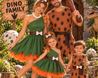 Puede incluir: Un conjunto de disfraces familiares que incluye dos vestidos verdes de un solo hombro con borde de tul naranja, una túnica marrón sin mangas con puntos negros y un mameluco marrón sin mangas con puntos negros. Cada pieza incluye un cinturón marrón con hebilla de hueso blanco.